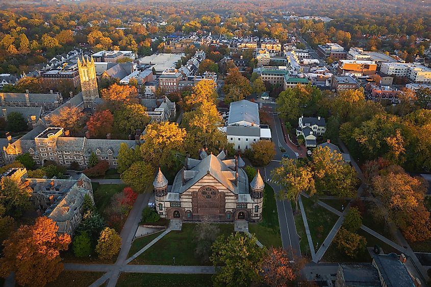 Aerial drone view of a sunrise over Princeton, New Jersey, with warm light illuminating the landscape and iconic architecture below.