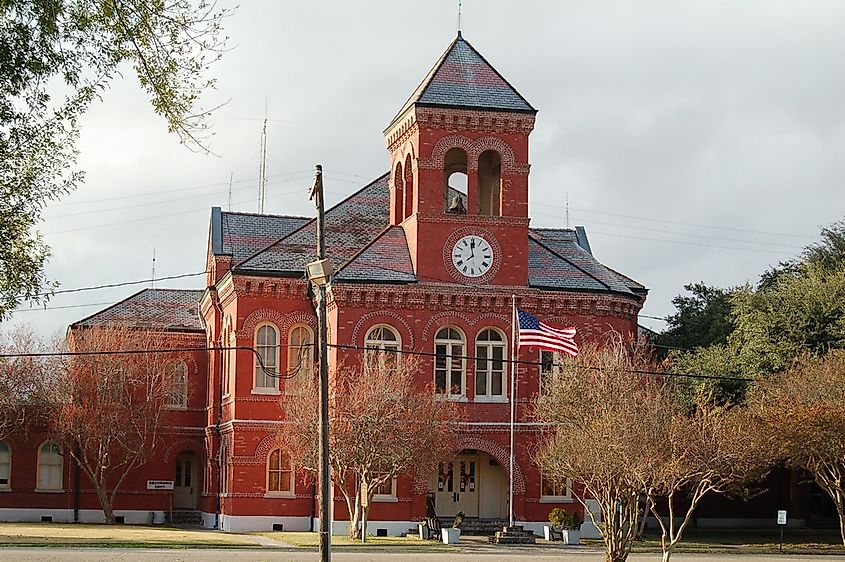 Historic red brick courthouse building in Donaldsonville, Louisiana, featuring a distinctive clock tower and an American flag.