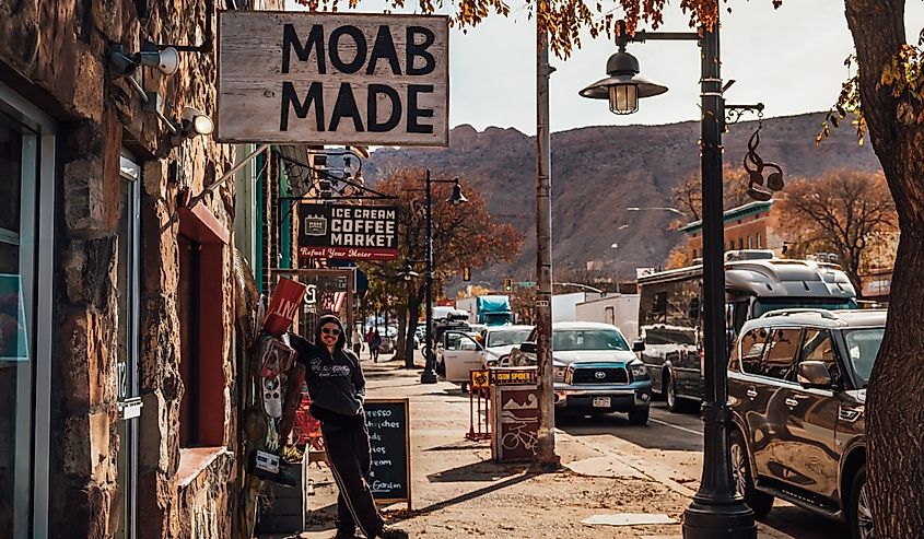 A tourist under a Moab Made sign in downtown Moab, Utah.