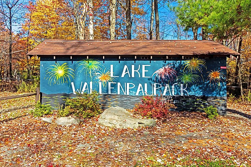 Lake Wallenpaupack sign in Hawley, Pennsylvania, on a bright fall day with colorful foliage in the background