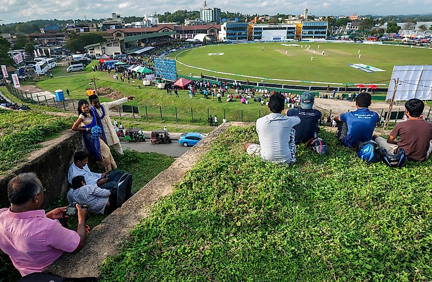 A newly married couple watching a cricket match from the old Dutch Fort at Galle, Sri Lanka. Image Credit Thomas Wyness via Shutterstock.