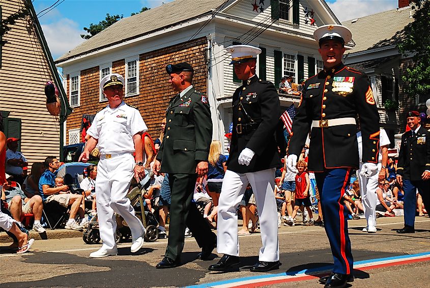 Members of all four United States armed services, in formal dress, marching in a Fourth of July parade in Bristol, Rhode Island, USA.