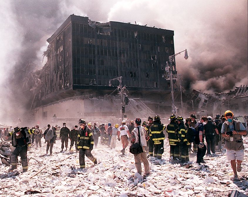 New York City firefighters and journalists stand near the area known as Ground Zero after the collapse of the Twin Towers September 11, 2001