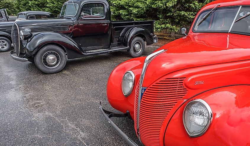 Old bright red restored Ford car parked by a black 1930's Ford truck in Clarkesville, Georgia.