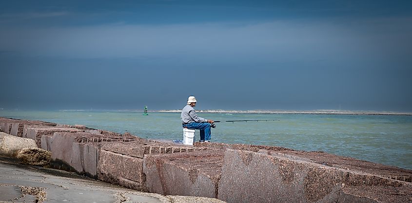 A man fishes from a jetty in Port Aransas, Texas.