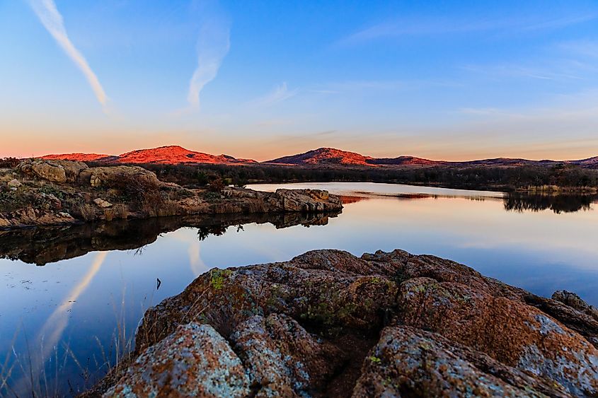 The sky and rocky edge reflects in the still water in the early morning at Wichita Mountains National Wildlife Refuge, November 2017.