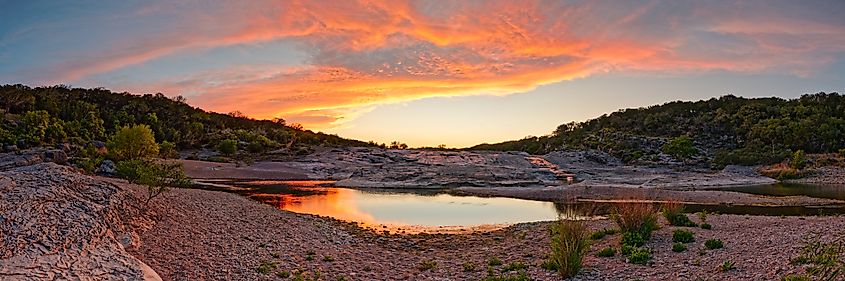 A breathtaking "fire in the sky" sunset over Pedernales Falls State Park in Johnson City, Texas Hill Country.