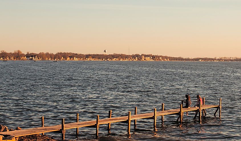 Dock jutting into Clear Lake with houses and buildings on shore. Image credit jerseyjoephoto via Shutterstock.