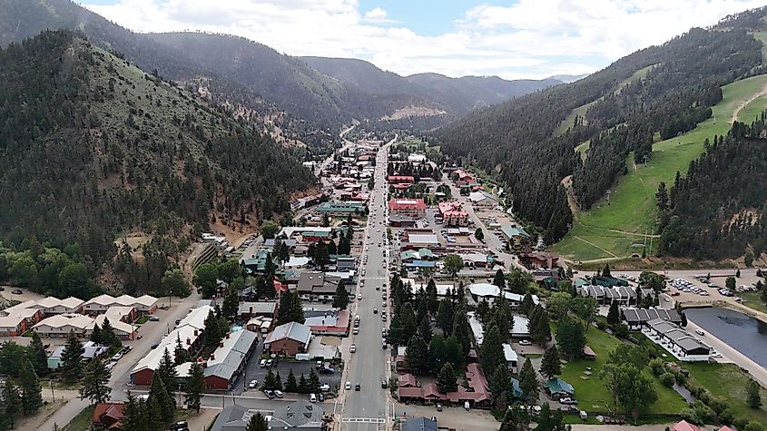 Red River, New Mexico, showcasing a lively summer atmosphere with scenic mountains, green landscapes, and bustling activity in the small western-style town.