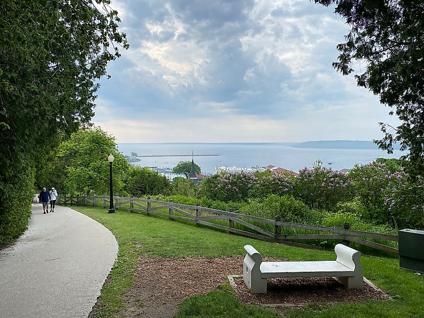 Two walkers coming up towards a panoramic bench lookout of beautiful Mackinac Island
