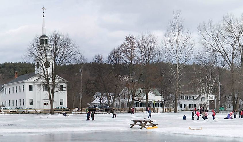 Panoramic view of the bandstand, town hall, church and elementary school from the skating rink on the town playground.