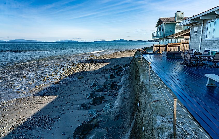 View of the shoreline in Oak Harbor, Washington, with the front of a home in the foreground, offering a scenic outlook of the water and surrounding natural beauty.