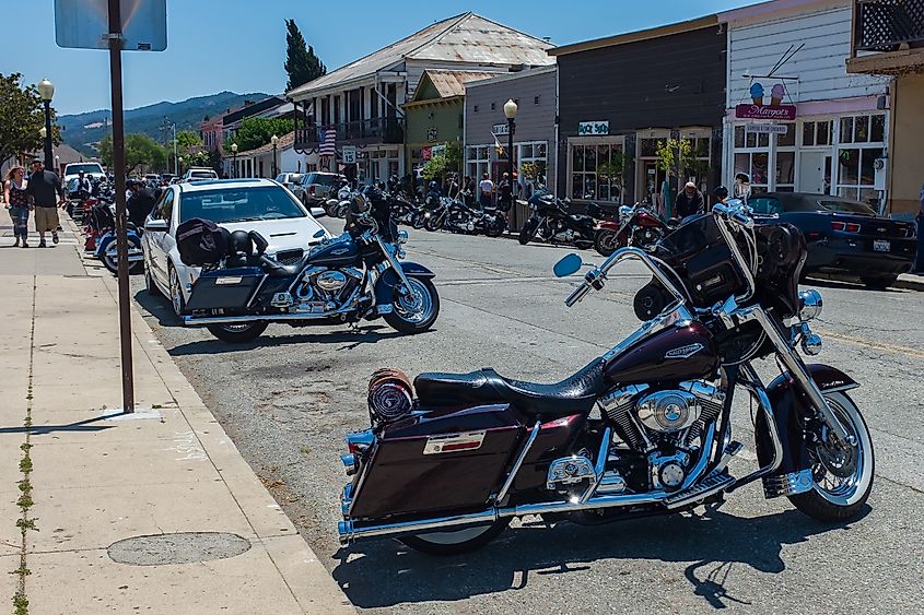 Two gleaming Harley Davidsons with the blue sky reflected in their polished chrome on San Juan Bautista's Third Street.
