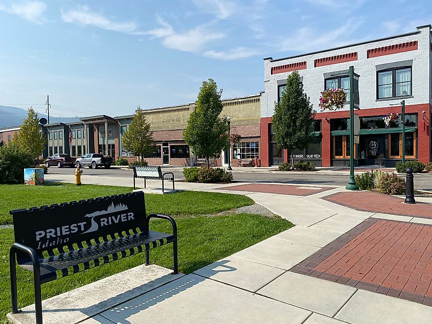 A park bench inscribed with Priest River, Idaho, stands in front of the downtown core. 