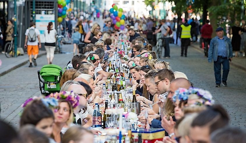  Long table with lots of people eating and drinking together. The Day of City Celebration in centre of Helsinki.