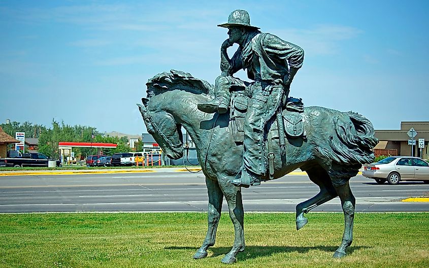 Statue of Cowboy resting on his horse with the town of Lander in the background