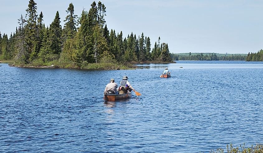 Senior campers head out in a canoe on a northern Minnesota lake with their guides for a Boundary Waters camping trip