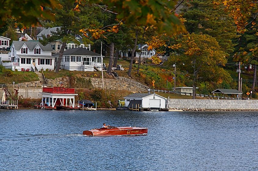 Wooden Hacker Craft speed boat cruising Alton Bay shoreline 