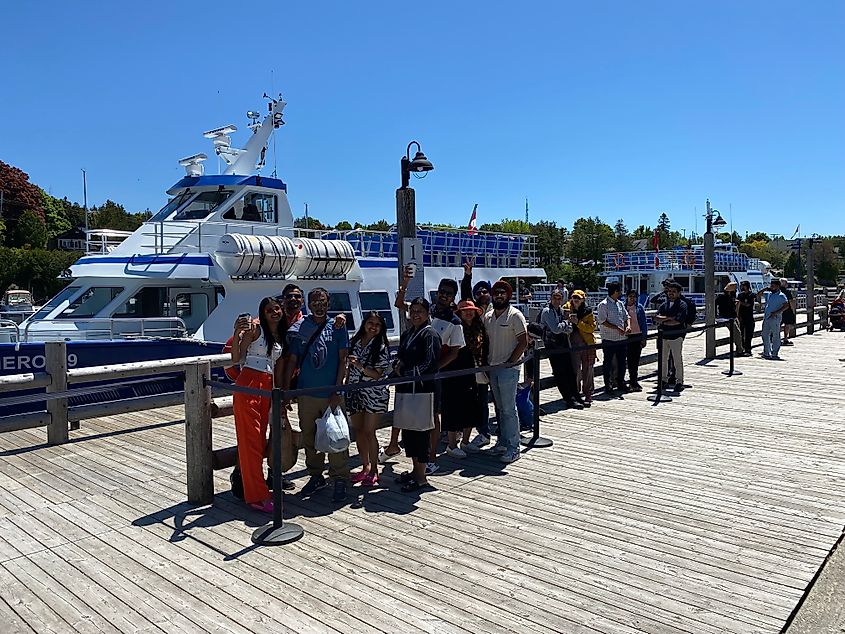 A group of tourists wait to board a boat in Tobermory’s Little Tub Harbour