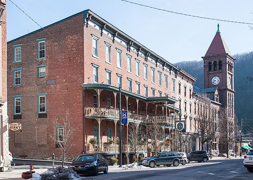 The Inn at Jim Thorpe in Jim Thorpe, Pennsylvania, with its red brick exterior, decorative railings, and a clock tower beyond.