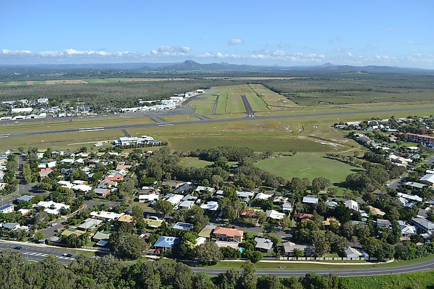 Marcoola residences with Mount Coolum National Park and Sunshine Coast Airport runway in the background. Image Credit Liv Gaunt via Shutterstock.