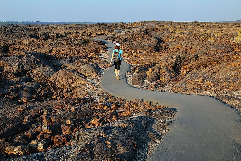 Woman walking on a trail to the cave area, Craters of the Moon National Monument, Idaho, USA..