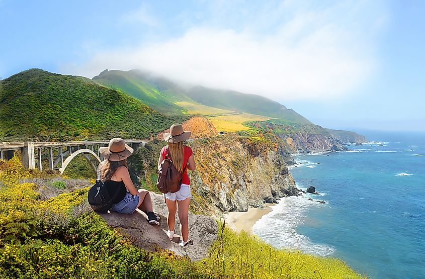 Tourists admiring scenic coastal views in Big Sur, California.
