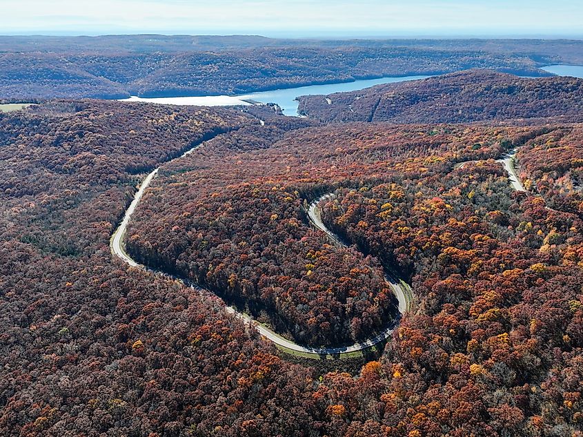 Winding road to Lake Fort Smith in the Ozark Mountains, surrounded by beautiful fall foliage.