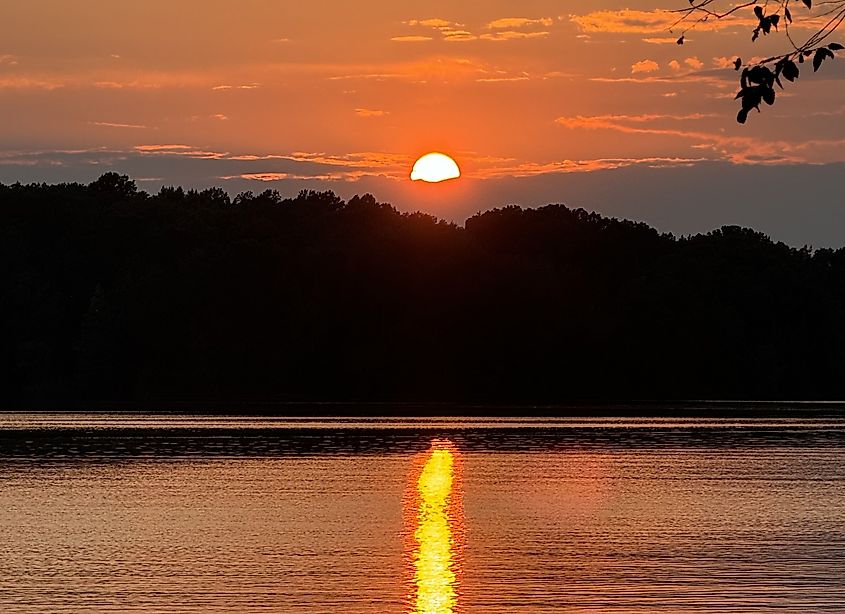 Sunset over Kentucky Lake in July, with vibrant orange hues reflecting on the water