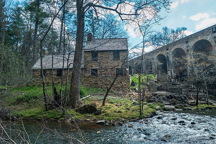 The Mill House Lodge behind the bridge with the dam along the stream in Cumberland Mountain State Park