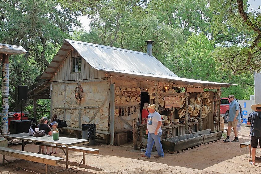 Außenansicht des Gebäudes der Open-Air-Firma Snail Creek Hat Company, Cowboy Hats, in Luckenbach – Luckenbach, Texas, über JustPixs / Shutterstock.com