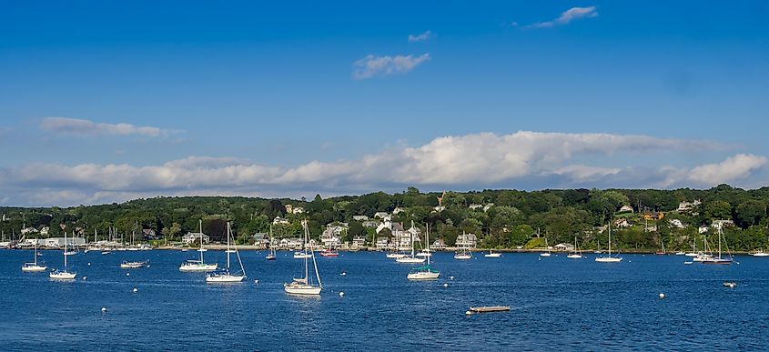 Panoramic view of Tiverton, Rhode Island, featuring sailboats moored in the harbor with the town's residential areas visible in the background