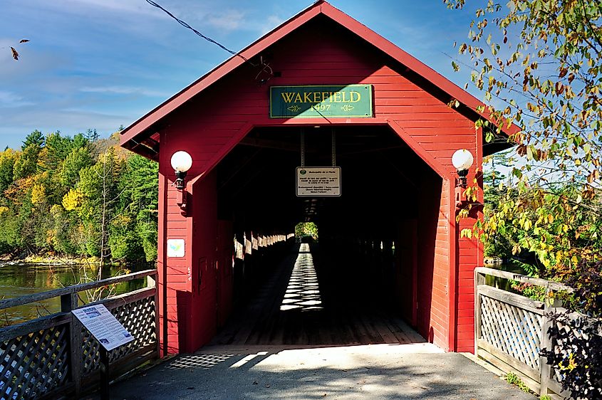 Covered bridge over Gain Wakefield Quebec in autumn colors.
