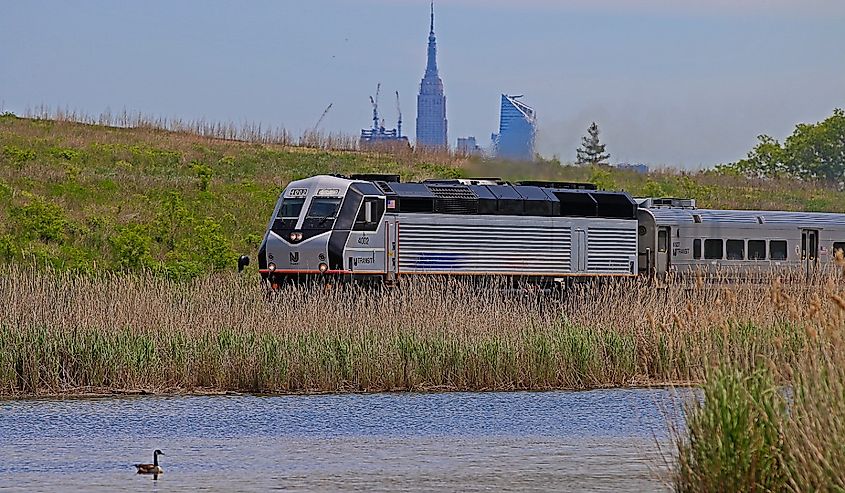 New Jersey Transit (NJT) Alstom PL42AC locomotive pulling a passenger train through the suburban New York City area of Lyndhurst, New Jersey.