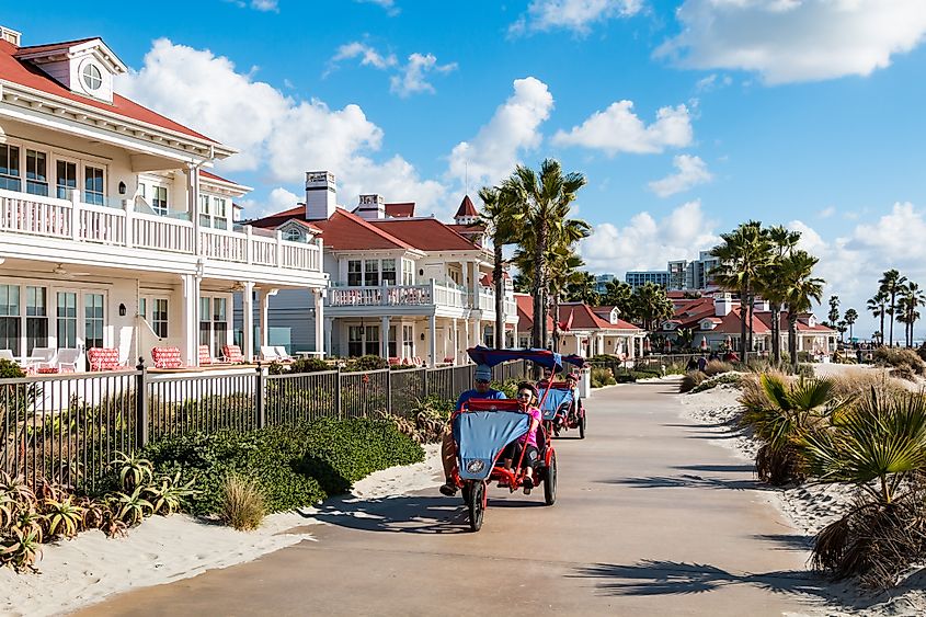 CORONADO, CALIFORNIA: People pedal on surrey bikes past the Hotel del Coronado. 