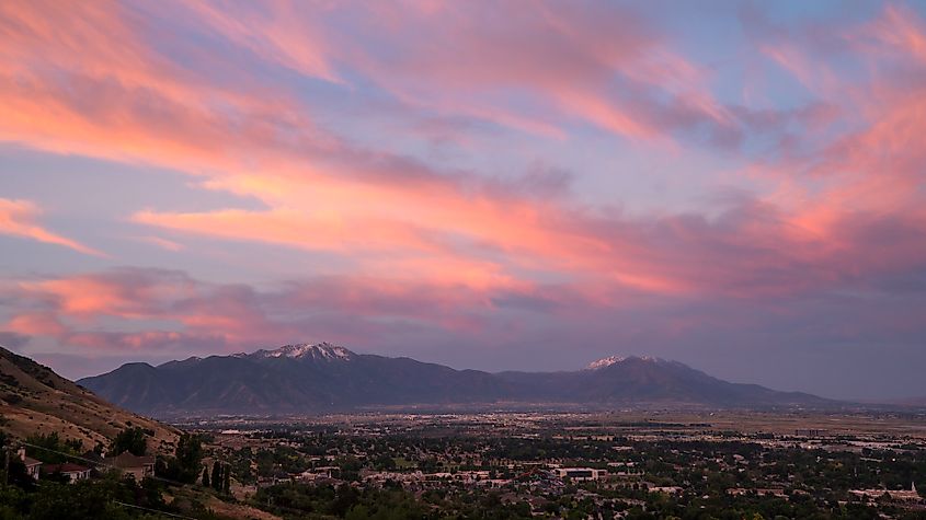 Colorful sunrise looking over Provo towards Spanish Fork viewing the cities across the valley and Nebo Mountain in the distance.