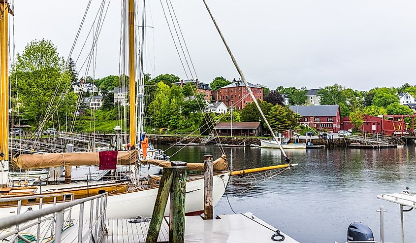 Empty marina harbor in small village in Maine during rain with boats and view of downtown.