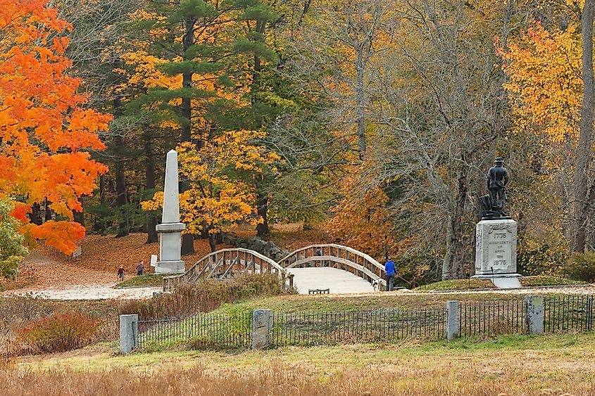  The Minute Man statue and North Bridge at Minute Man National Historic Park with fall foliage as background, Concord, Massachusetts. Editorial credit: Jay Yuan / Shutterstock.com