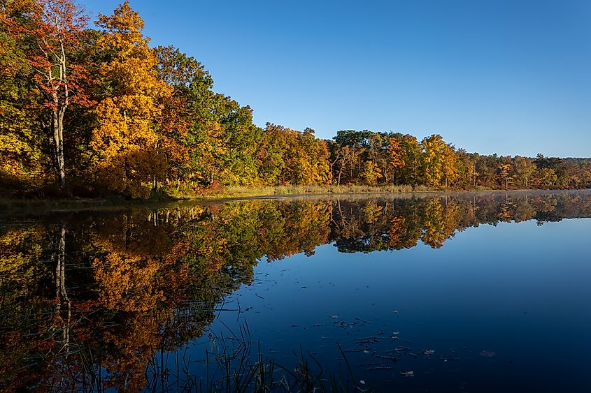 Sawmill Lake in High Point State Park, NJ, on a quiet and calm Autumn morning surrounded by brilliant fall foliage.