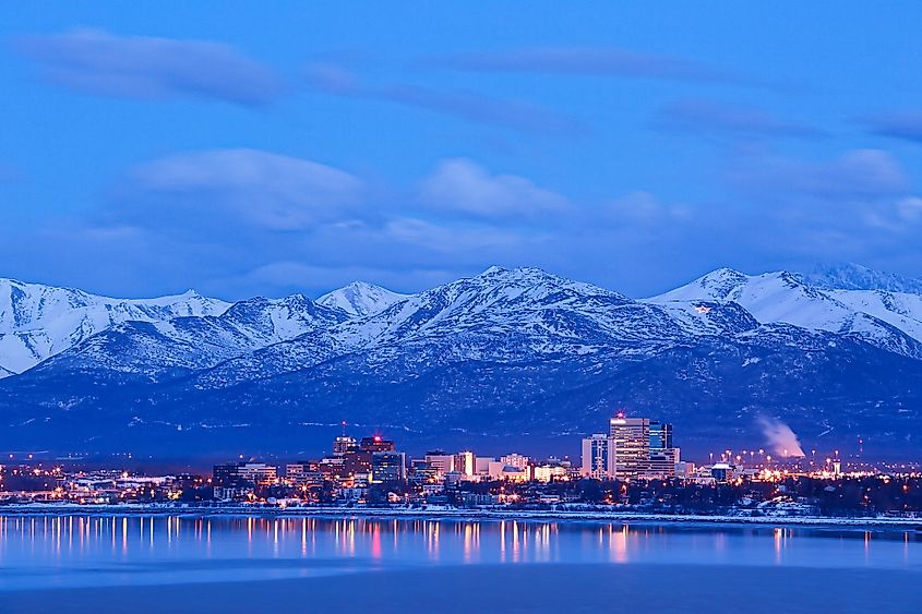 The skyline of Anchorage, Alaska, with mountains behind.