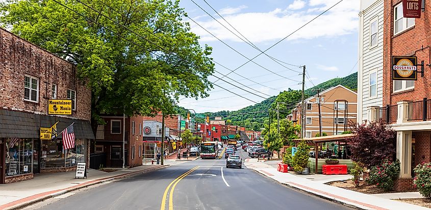 Main Street in Boone, North Carolina in summer, featuring people, cars, and businesses in a wide-angle view