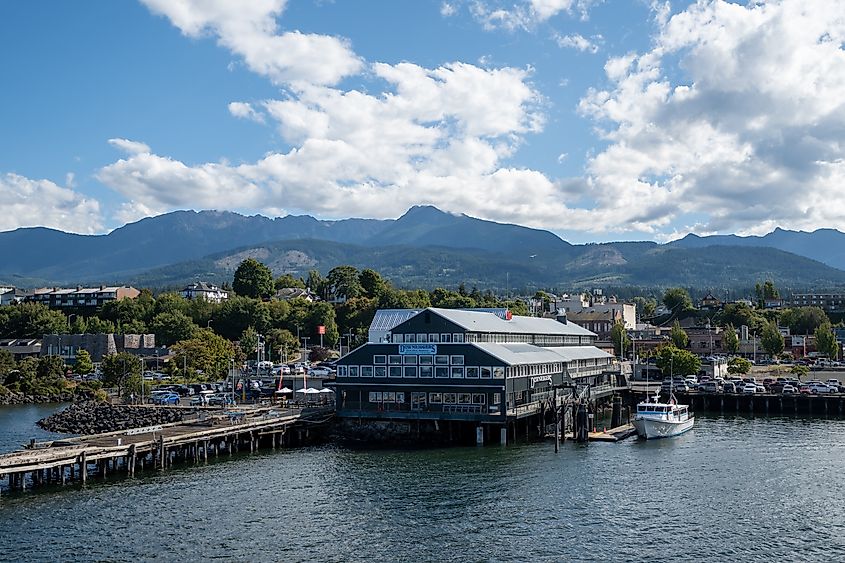 View of city and Olympic Mountains under bright summer cloudscape from ferry in Port Angeles, Washington. Editorial credit: Francisco Blanco / Shutterstock.com