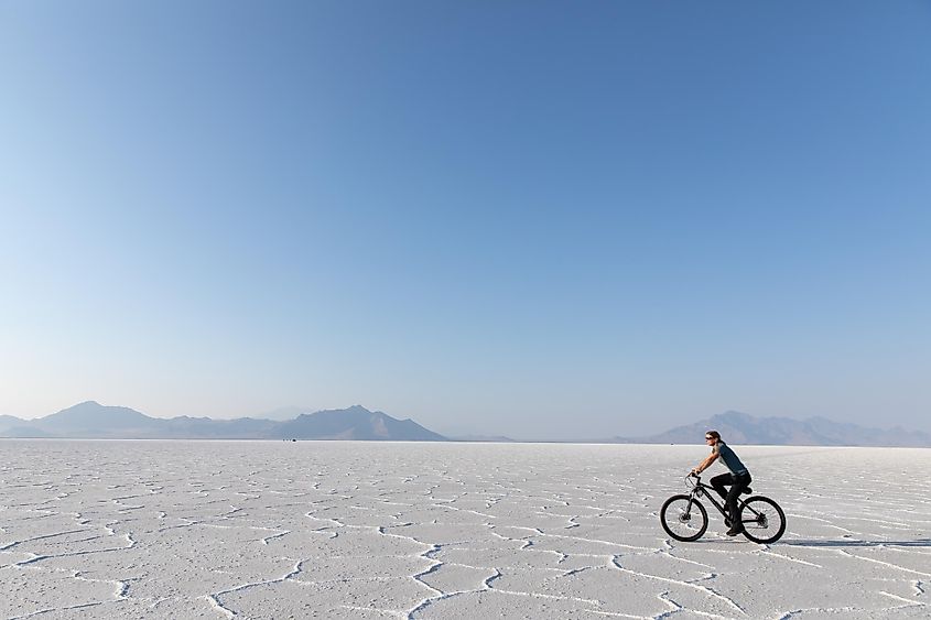 Woman riding a bike on Bonneville Salt Flats in Utah.
