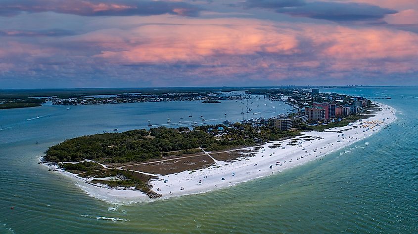 Drone photo of Fort Myers Beach, showcasing the sandy shoreline, ocean waves, and beachfront buildings from above.