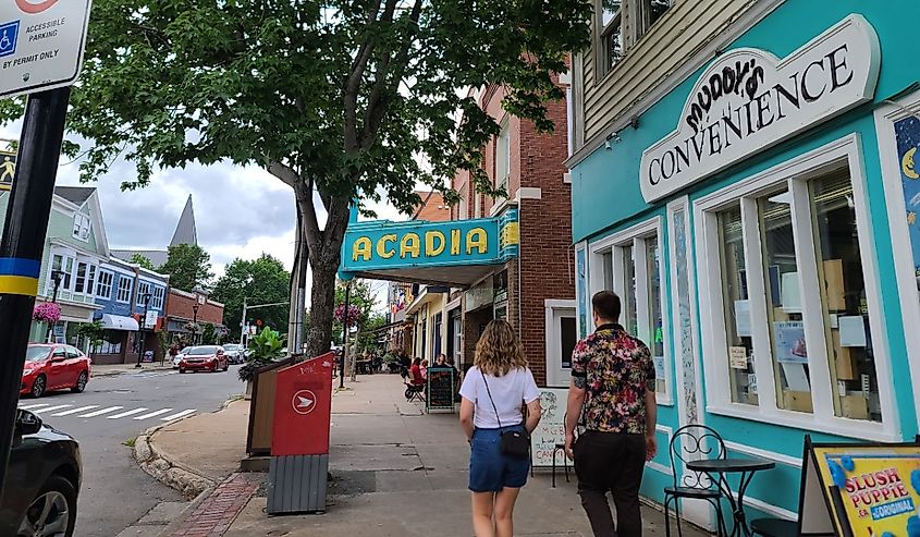 A sidewalk shot along the main street of Wolfville NS, which is home to Acadia University. Muddy's Convenience store is ahead