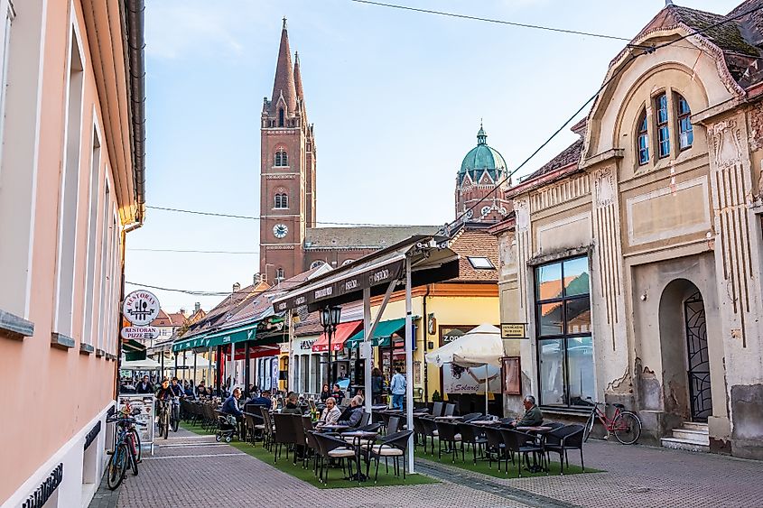 A vibrant pedestrian street lined with outdoor cafés and a view of St. Peter’s Cathedral in the background. (Editorial credit: Ivan Klindic / Shutterstock.com)