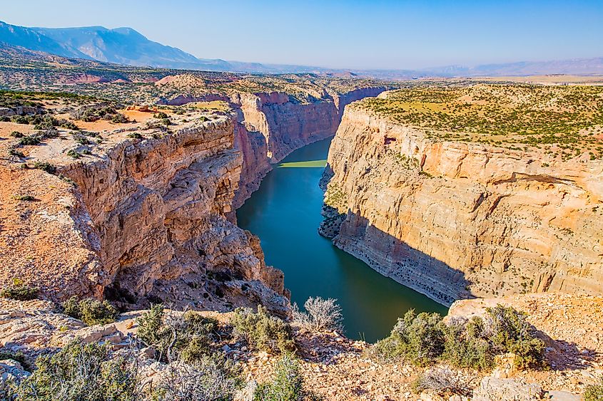 Expansive view of Bighorn Canyon National Recreation Area, showcasing towering red rock cliffs, the winding Bighorn River, and rugged landscapes spanning Wyoming and Montana.