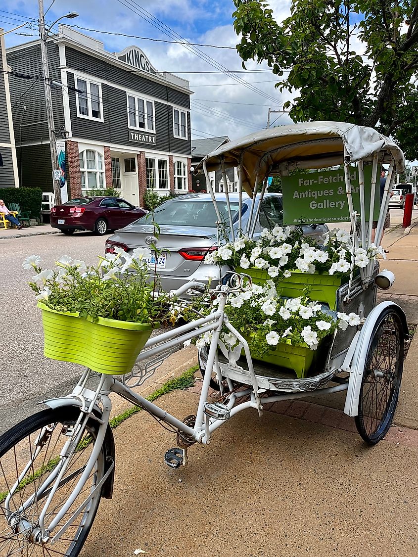 A bike cart with flowers for sale in front of the King's Theatre, Annapolis Royal