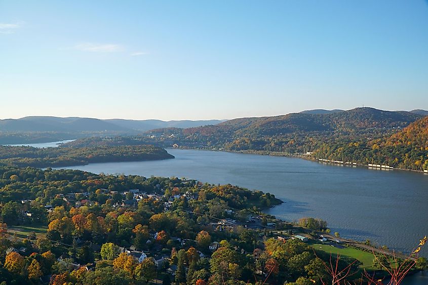 Beautiful scenic overlook view of Hudson River valley on an autumn morning, sunrise over the hills. Fall foliage on trees throughout the countryside.