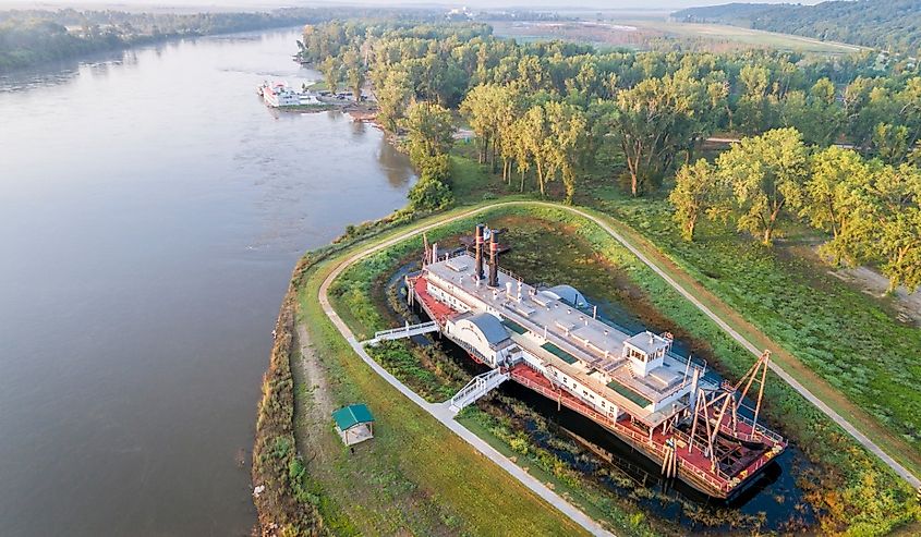 Hazy sunrise over the Missouri River with the historic dredge, Captain Meriwether Lewis in Brownville, Nebraska.